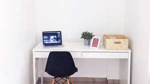 A white desk with a laptop, a potted plant, and a wooden box. - Boulevard 302 (Mayagüez)