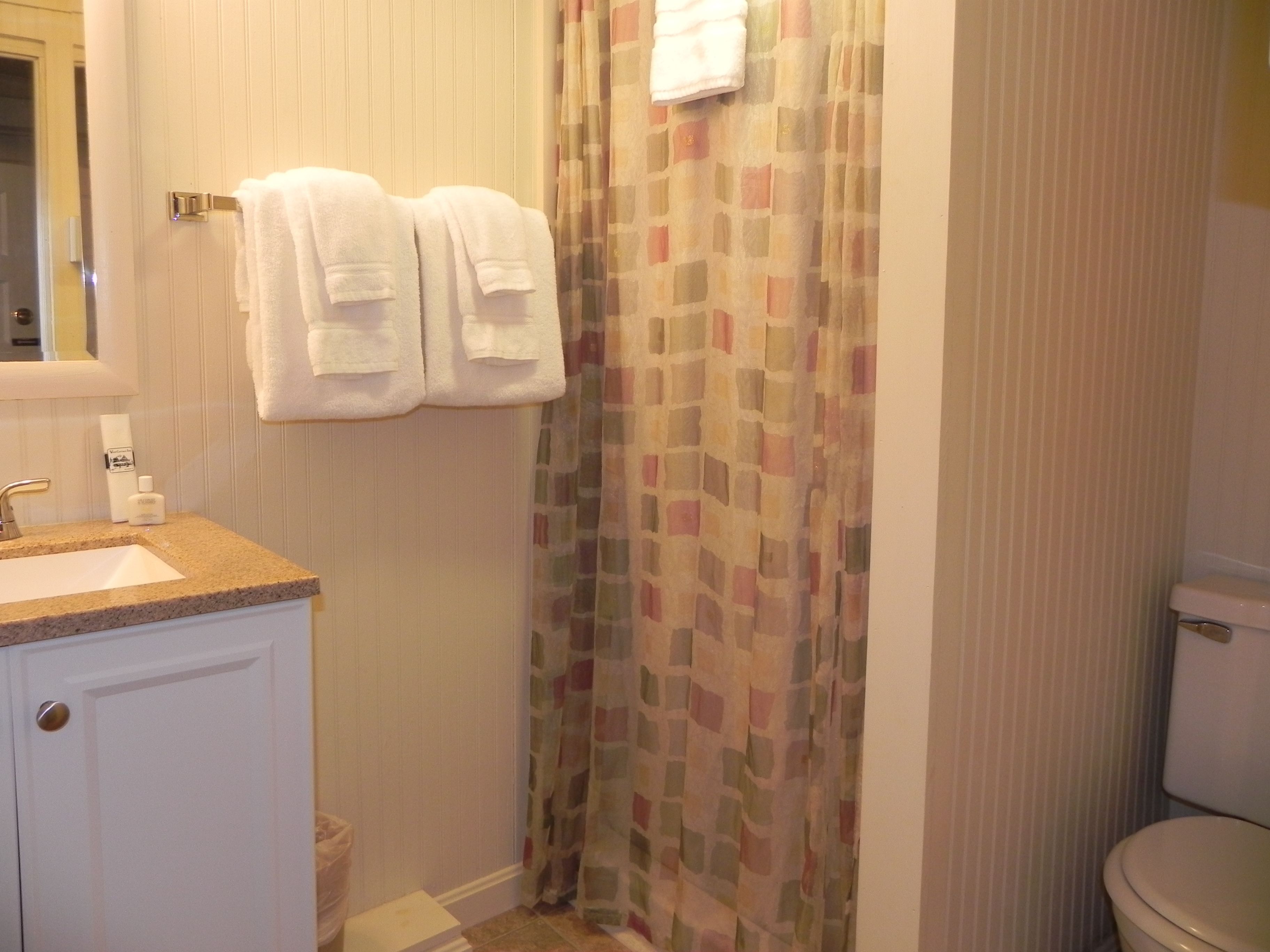 Ein Badezimmer mit Waschbecken, Toilette und Duschvorhang.