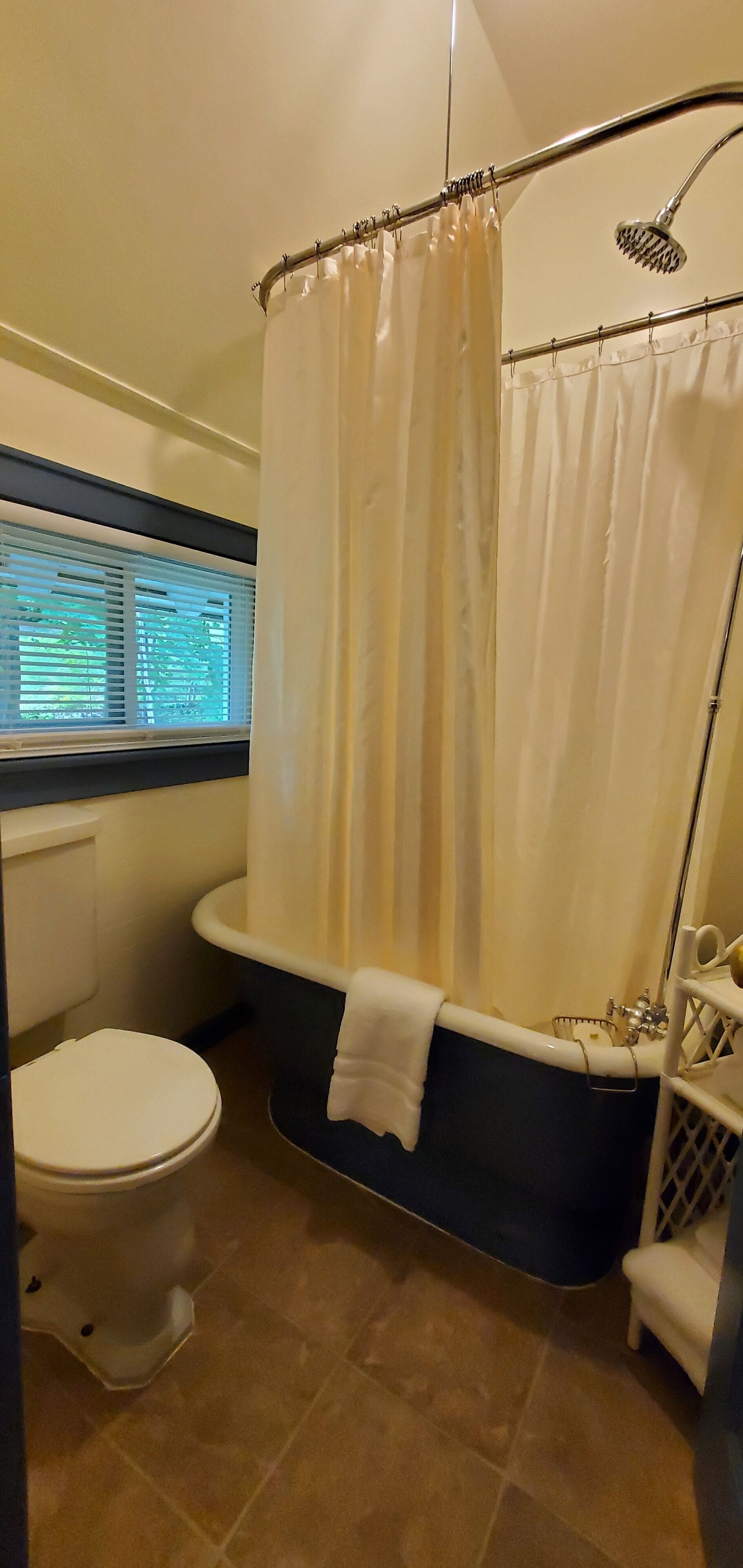 Un baño con inodoro, bañera y cortina de ducha.