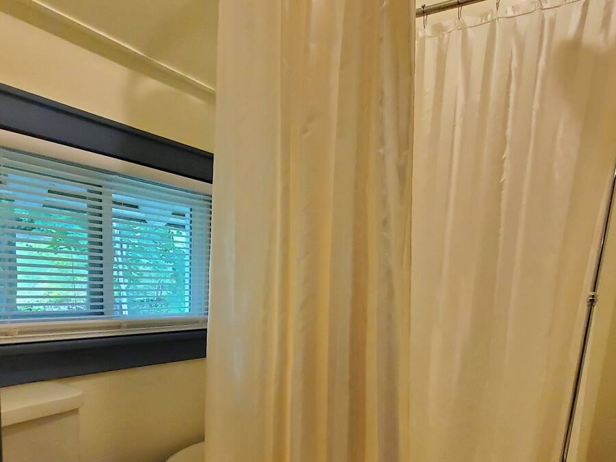 A bathroom with a toilet, bathtub, and shower curtain.