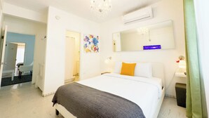 A hotel room with a bed, a mirror, a chandelier, and a window with curtains. - Aibonito Hotel 208 (Aibonito)