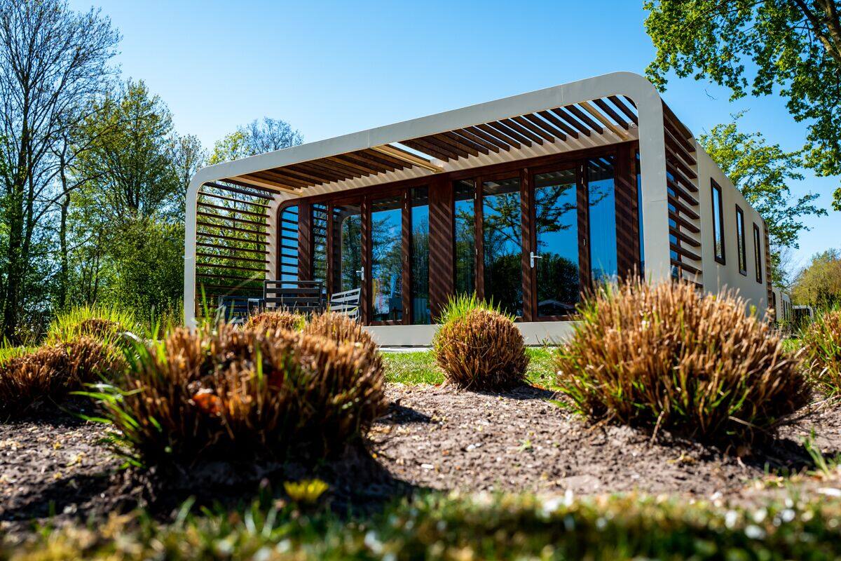 Un edificio moderno de una sola planta con ventanas amplias y una estructura de techo inclinada.