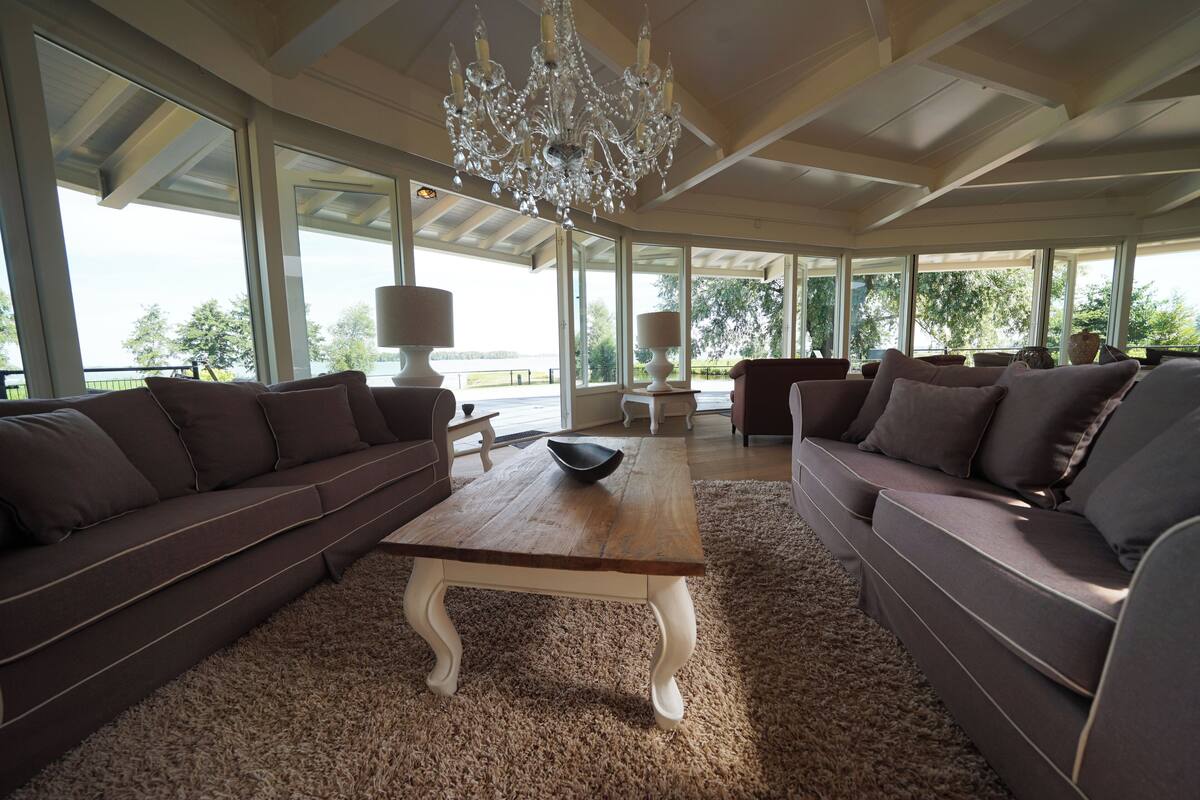 Un salón amplio con una gran mesa de centro de madera, dos sofás y una araña.