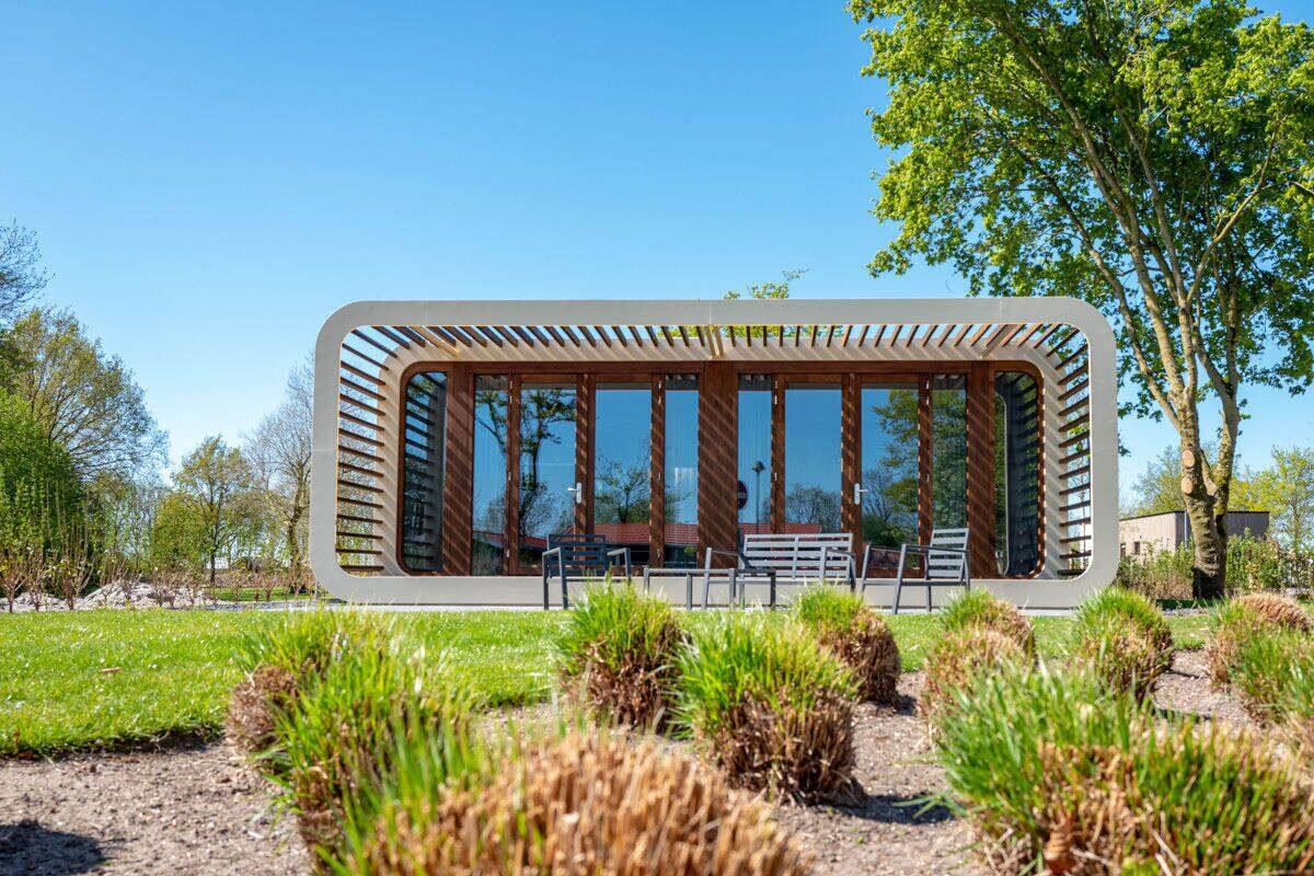 Un edificio moderno con un diseño arquitectónico único, con amplios ventanales y un tejado de listones de madera.