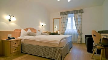 Una camera da letto con un letto, comodini, una sedia, una scrivania e una finestra con tende.