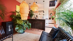 A cozy living room with a black sofa, a television, and a large plant. - EuroParc De Zanding (Otterlo)