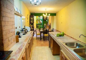 Une cuisine dotée d’un îlot central, d’un évier et d’un coin repas avec des chaises.