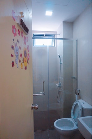 A bathroom with a glass shower enclosure, a toilet, and a sink. - Line Friends Homestay Atlantis Melaka (Malacca City)