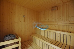 A wooden sauna with a bench and a stone basin. - Line Friends Homestay Atlantis Melaka (Malacca City)