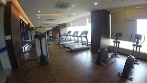 Academia com esteiras, elípticos e equipamentos de musculação.