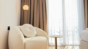 A modern living room with a round, plush sofa, a small side table, and a floor lamp.