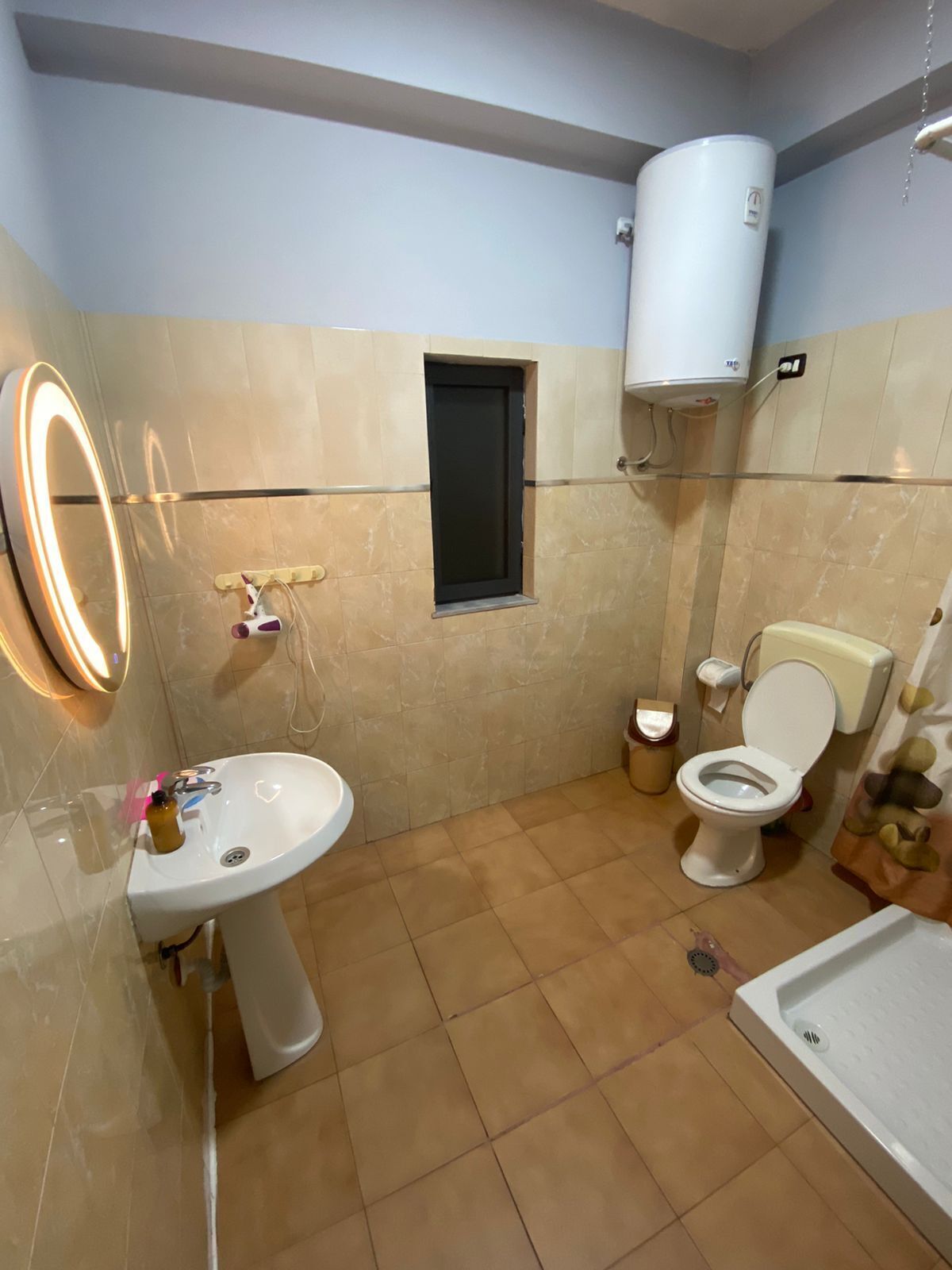 A bathroom with a sink, toilet, and a shower area.