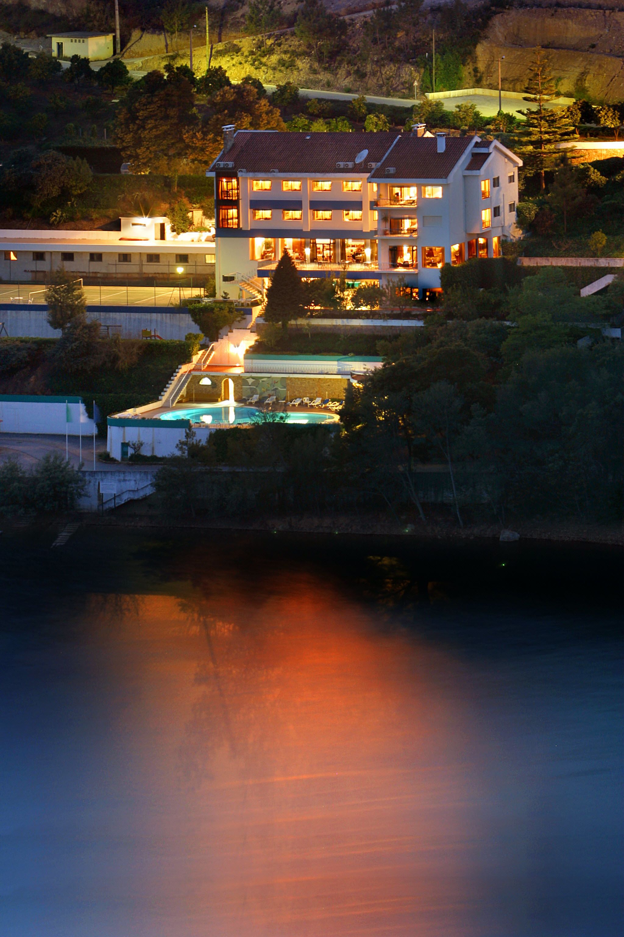 Un hotel de varios pisos con piscina y vistas al paisaje circundante.