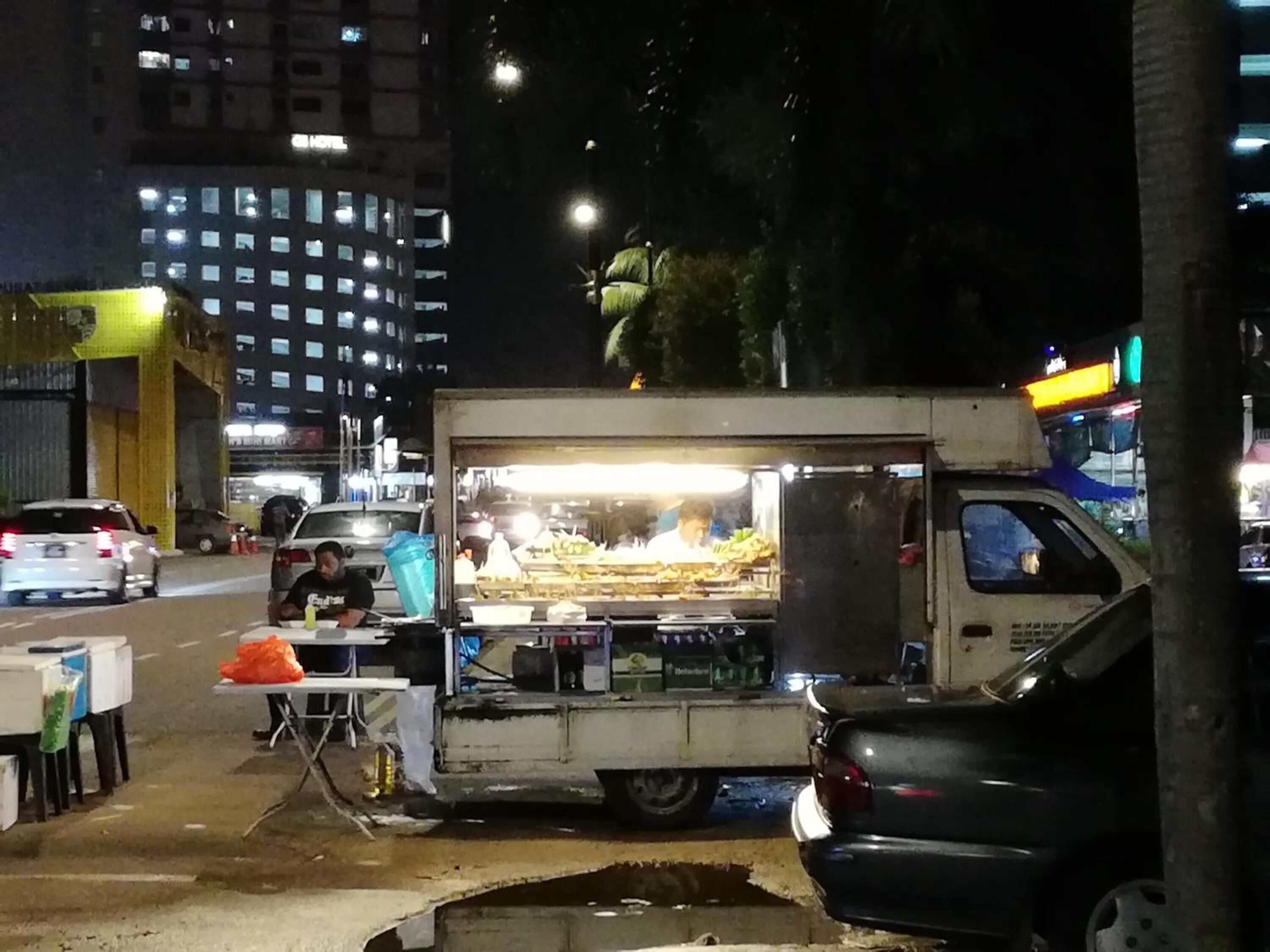 Een foodtruck op een stadstraat, 's nachts.