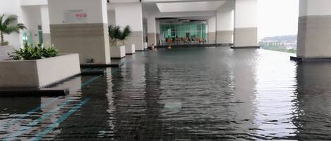 An indoor swimming pool with tiled flooring and a red staircase.