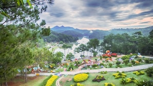 A landscaped garden with a pond, pathways, and decorative elements. - Jolie House (Lam Vien - Da Lat)