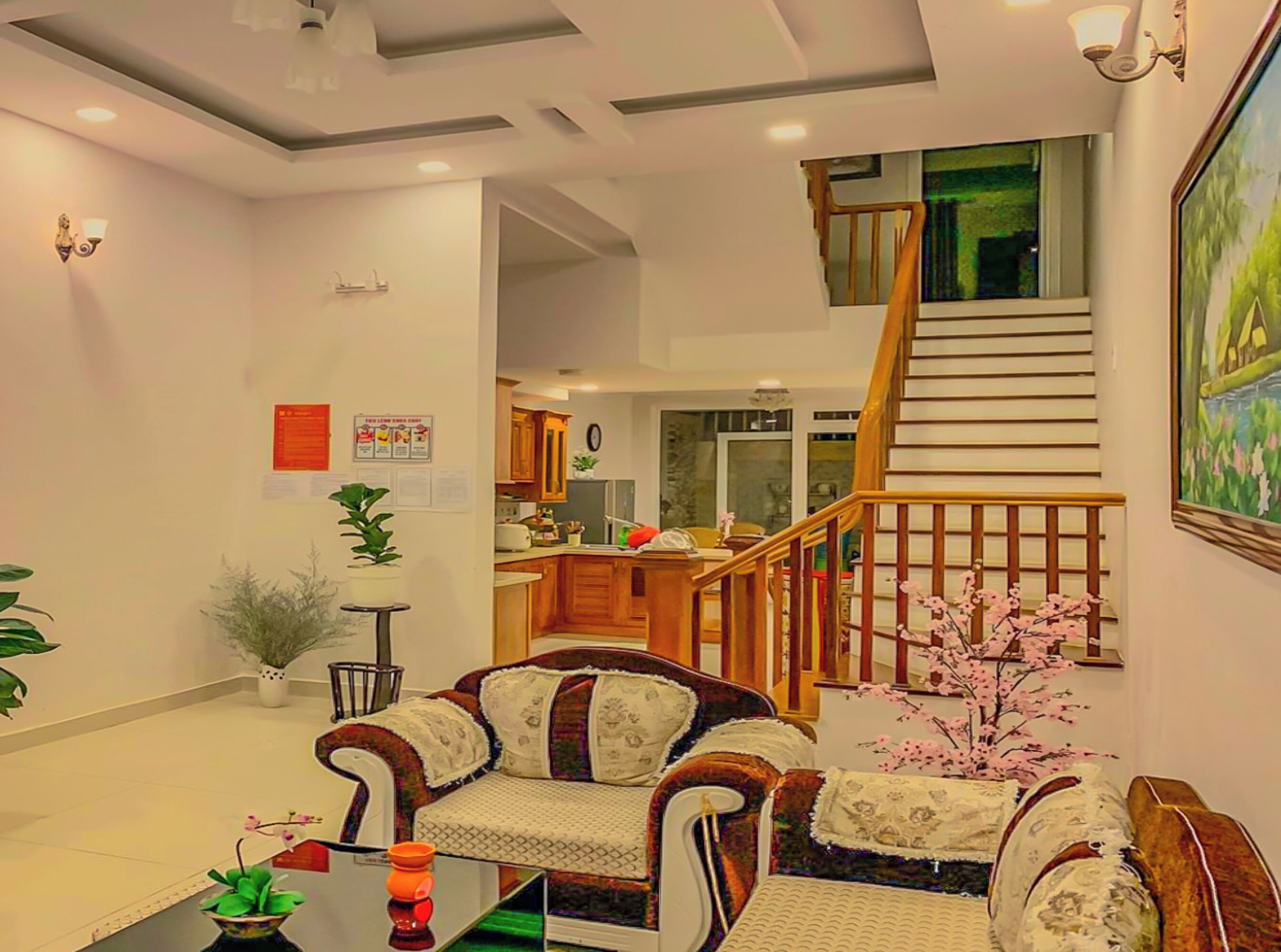 A living room with a sofa, a coffee table, and a staircase leading to an upper floor.
