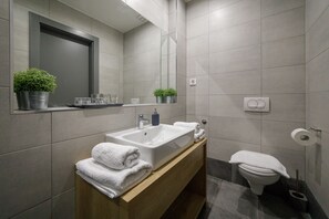 A modern bathroom with a sink, mirror, and toilet. - Hotel Arhiv (Novi Sad)