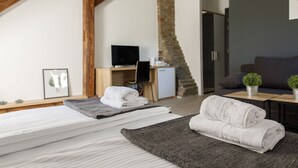 A modern bedroom with a bed, a desk, a television, and a sofa. - Hotel Arhiv (Novi Sad)