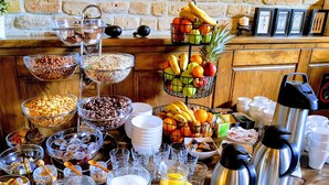 A buffet with various food items and beverages, including fruits, cereals, and coffee. - Hotel Arhiv (Novi Sad)