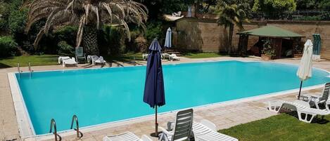 Outdoor pool, open 9 AM to 8 PM, pool umbrellas, pool loungers