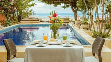 Una piscina al aire libre, sombrillas, sillones reclinables de piscina