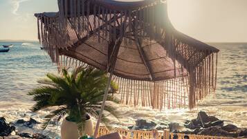 Relax in a tranquil beachside setting with a comfortable lounge chair and ocean views.
