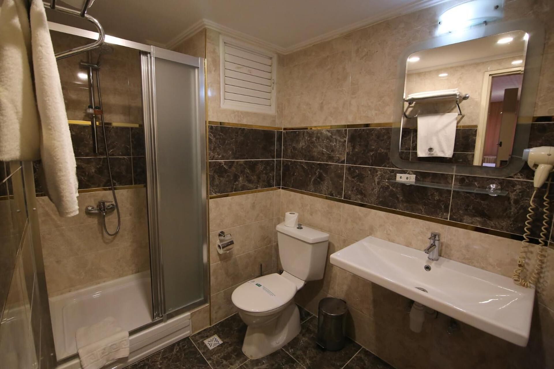 A bathroom with a shower, toilet, and sink.