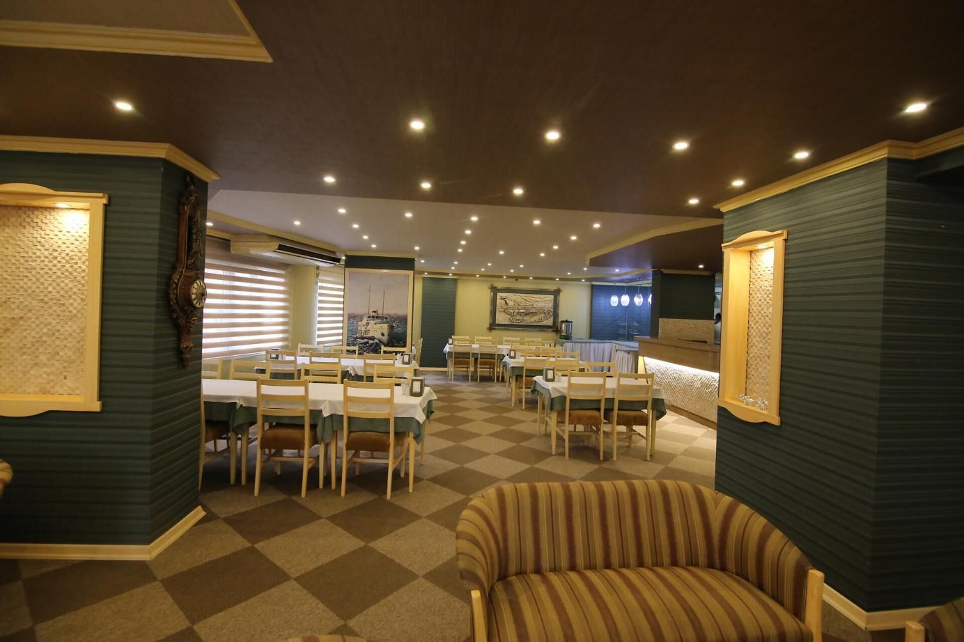 Un vestíbulo de hotel con piso a cuadros, muebles de madera y un sillón a rayas.