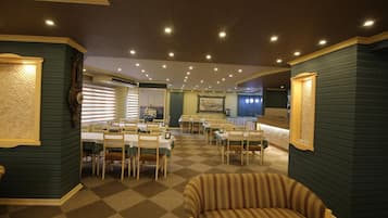 Un vestíbulo de hotel con piso a cuadros, muebles de madera y un sillón a rayas.
