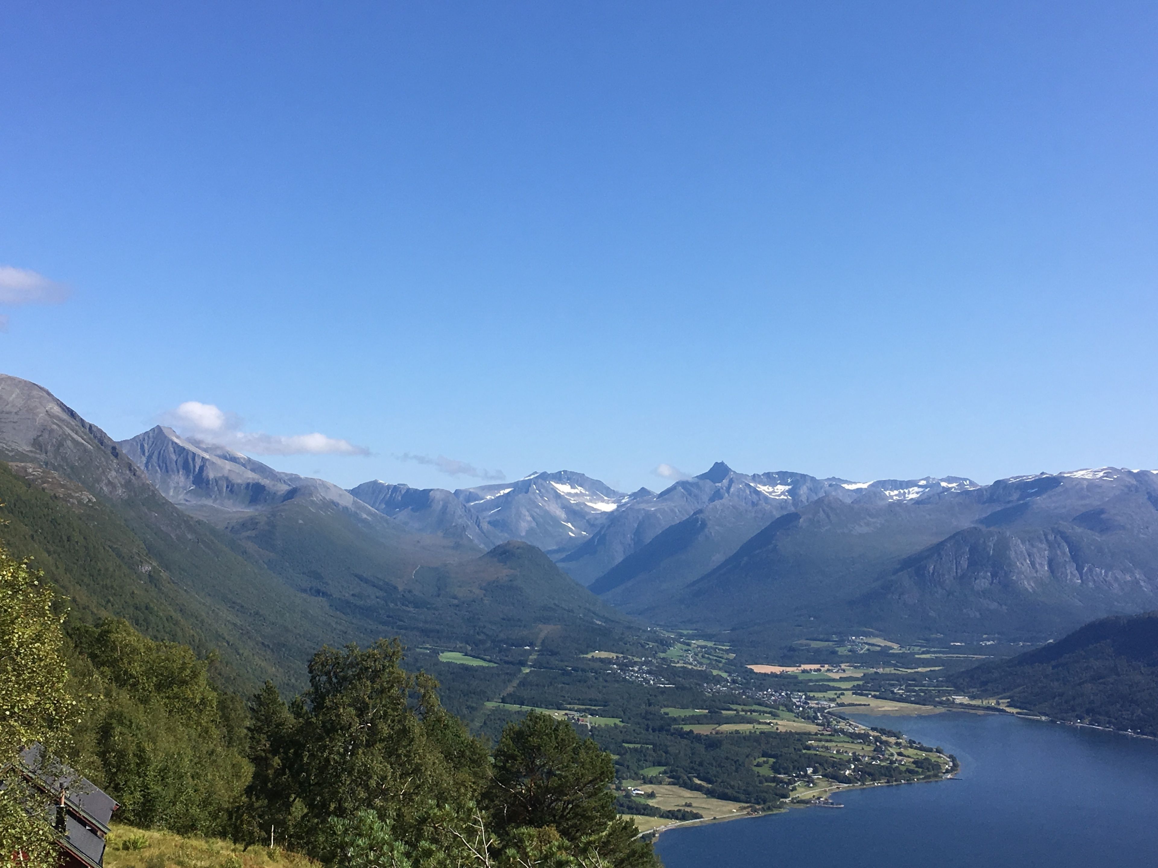 A mountainous landscape with a lake and a small settlement.