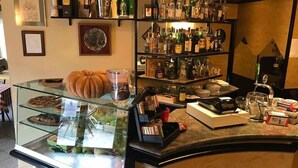 A bakery counter with pastries, a pumpkin, and a coffee machine. - Hotel Locanda l'Ombrosa (Vezzano Ligure)