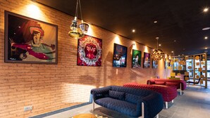 A modern lounge area with a brick wall, multiple sofas, and artwork.
