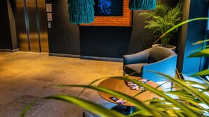 A lobby with a reception desk, seating area, and a potted plant. - ONOMO Hotel Casablanca City Center (Casablanca)