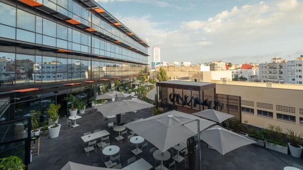 A rooftop terrace with outdoor seating, potted plants, and a view of the cityscape. - ONOMO Hotel Casablanca City Center (Casablanca)