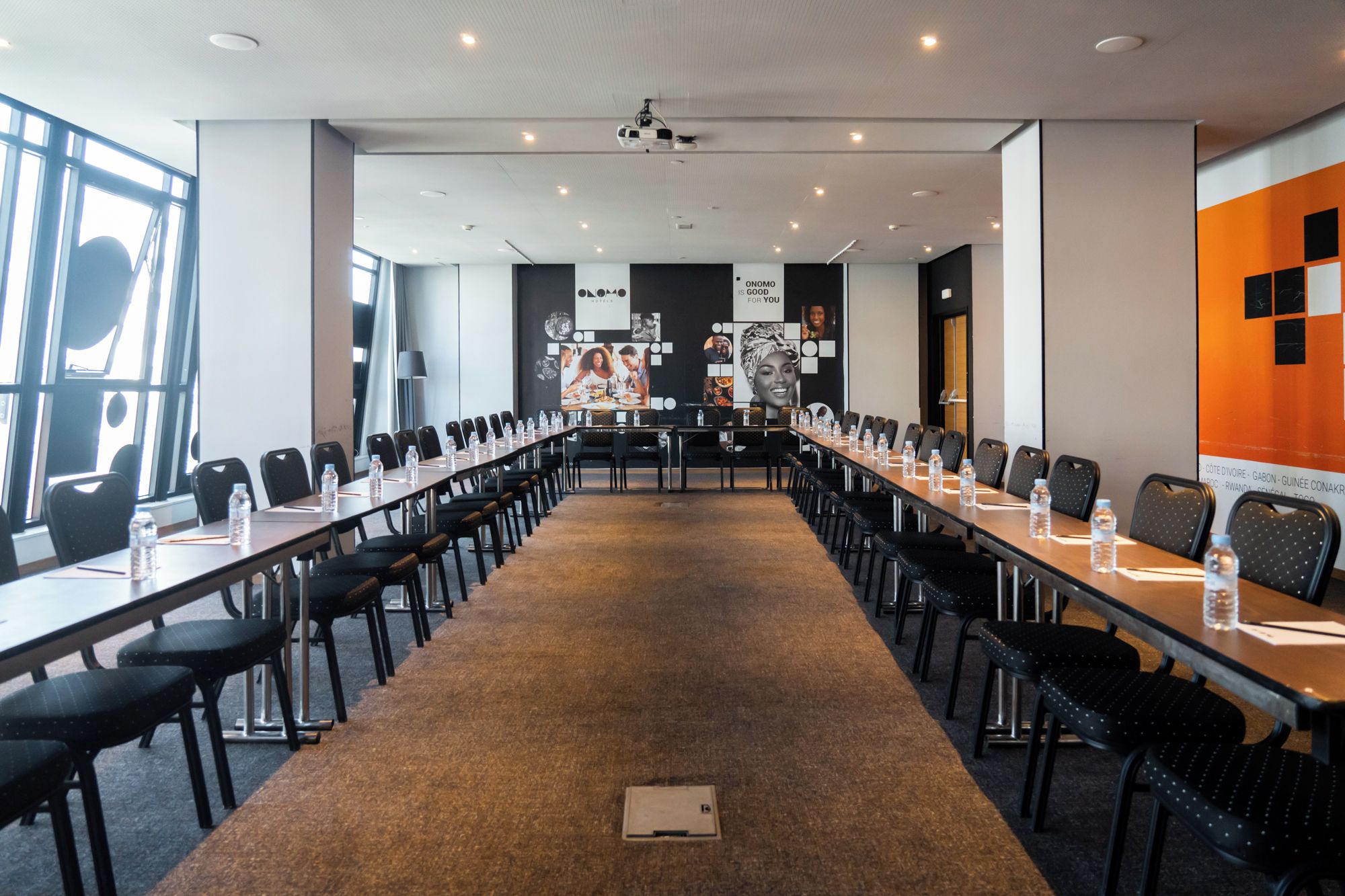 A conference room with a long table, chairs, and water bottles.