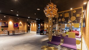 A modern lobby with seating areas, a chandelier, and a brick wall. - ONOMO Hotel Casablanca City Center (Casablanca)