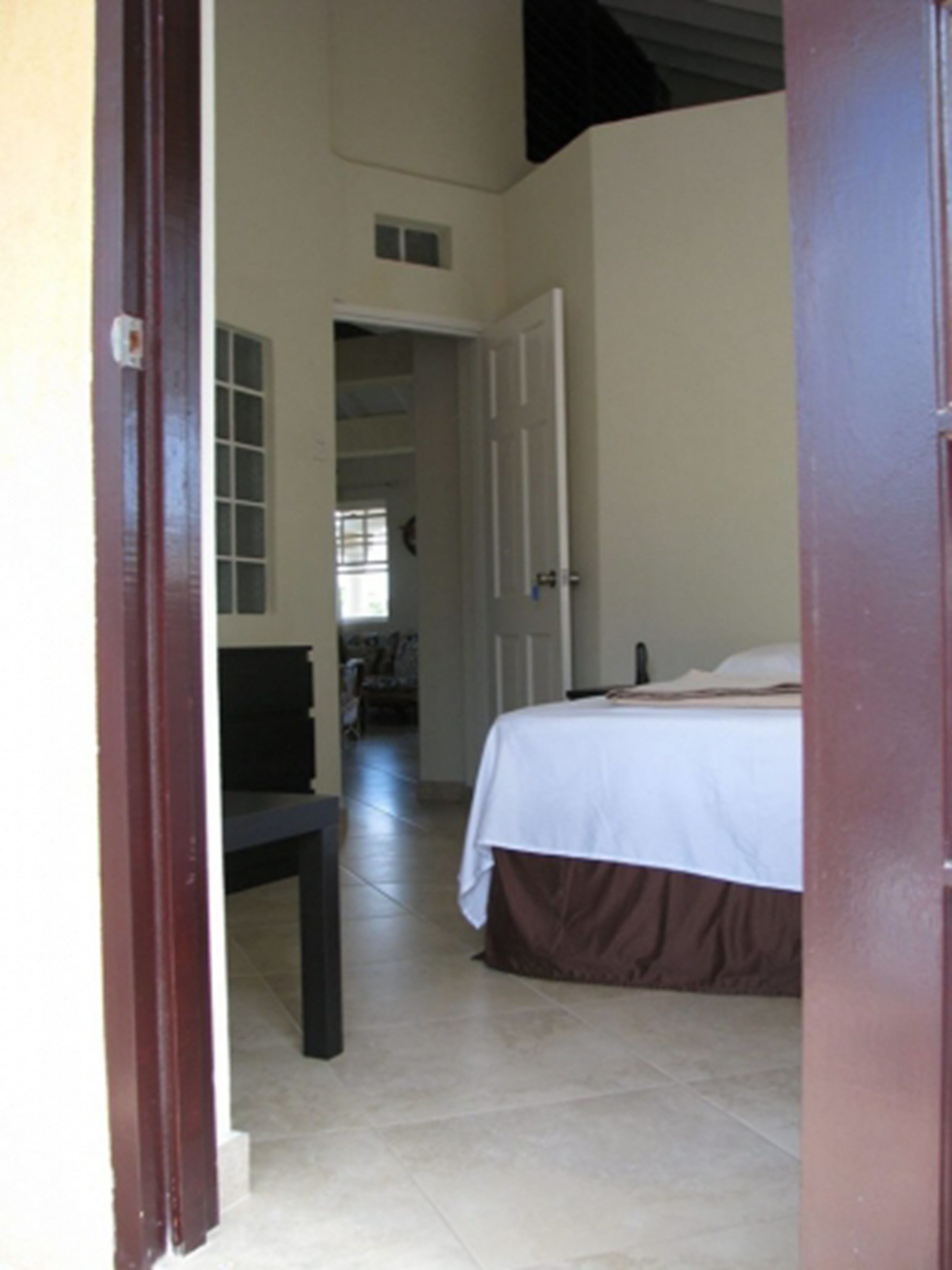A bedroom with a bed, a desk, and a chair.