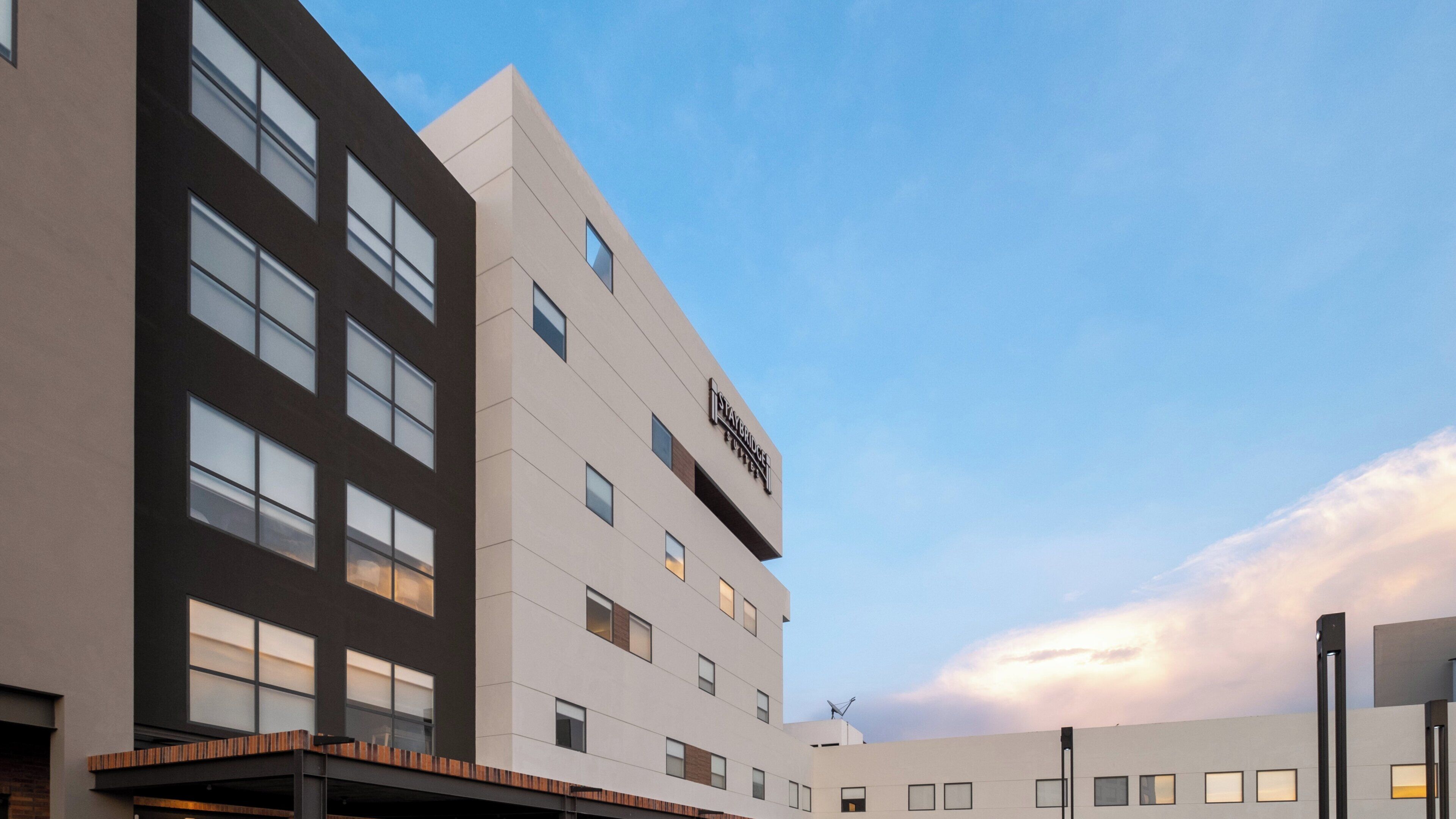 Un moderno edificio de hotel con fachada plana, múltiples ventanas y un letrero que indica el nombre 'Staybridge'.
