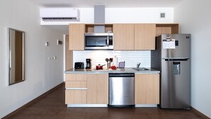 Una cocina moderna con armarios de madera, un refrigerador de acero inoxidable, un microondas y un lavavajillas.