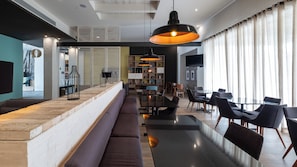 Ein modernes Interieur mit einer langen Bar, Sitzgelegenheiten und einem Essbereich.