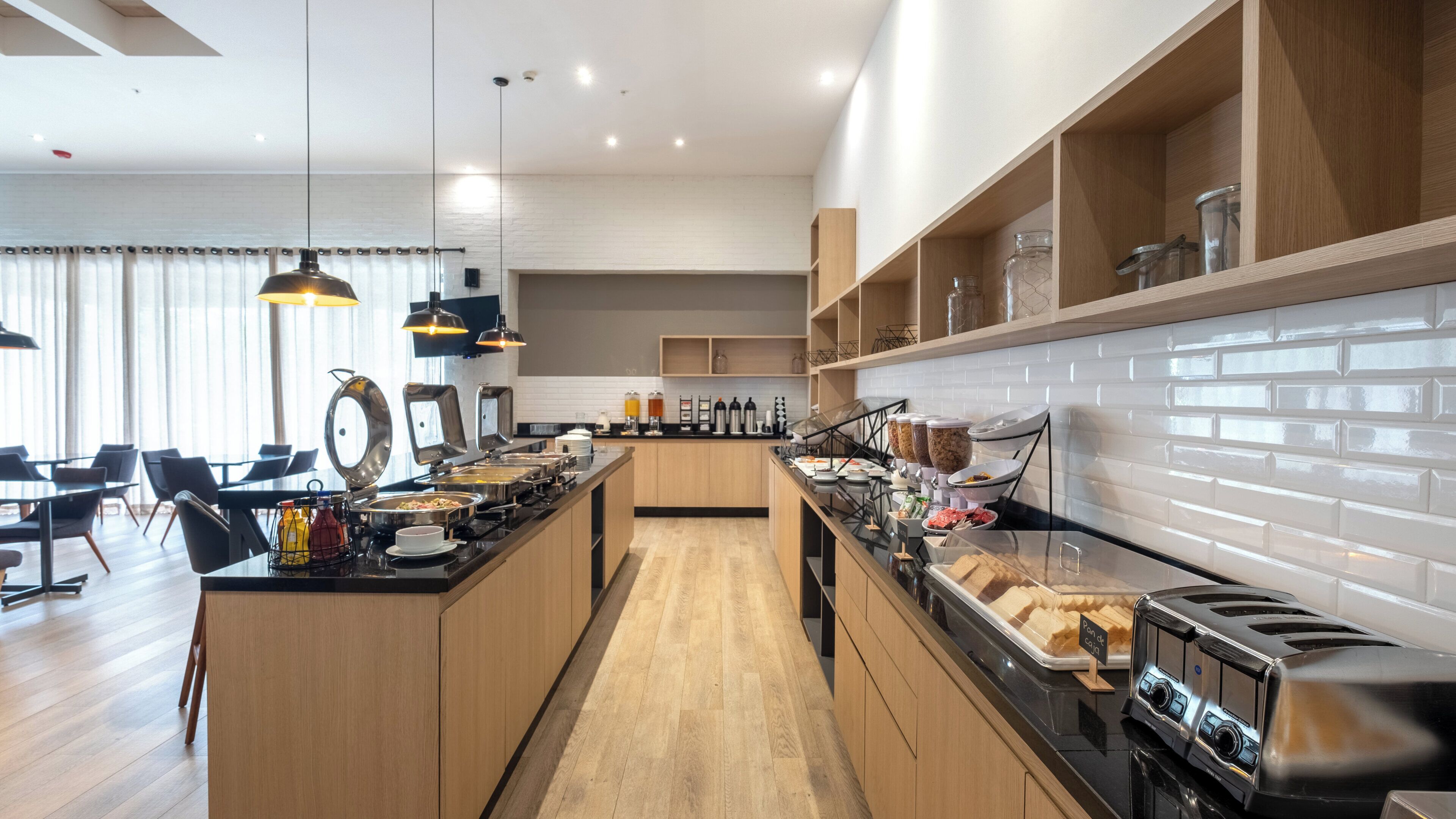 Une cuisine moderne dotée d’un îlot central, de meubles en bois et d’une variété de produits alimentaires exposés sur le plan de travail.