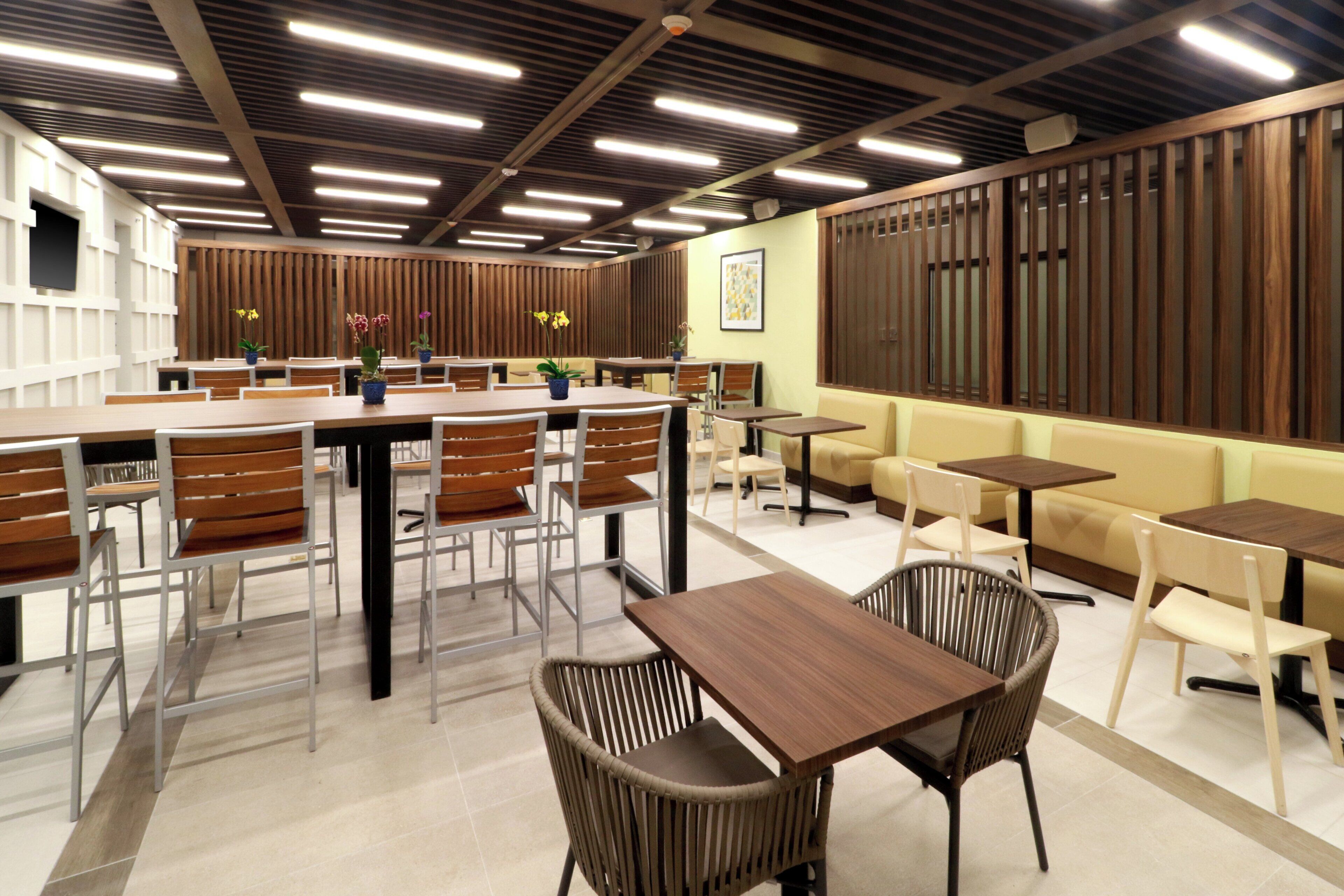 Ein modernes Restaurant-Interieur mit Barbereich, Sitzgelegenheiten und einer dekorativen Wand.