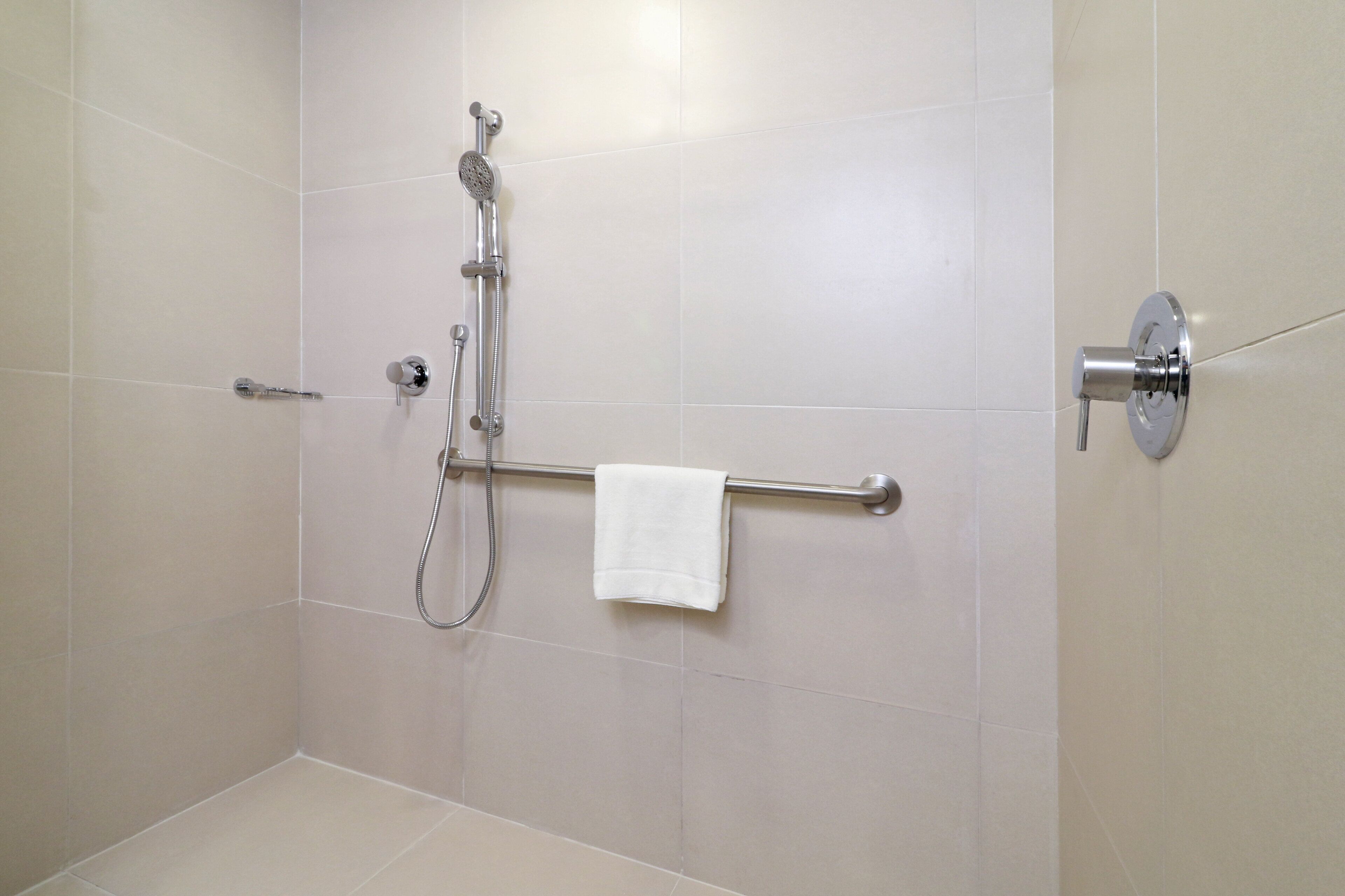 A bathroom with a shower, a towel rack, and a toilet.