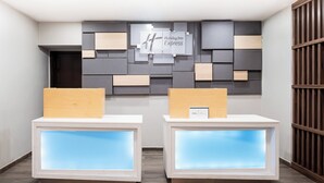 A reception area with two reception desks, a Holiday Inn Express sign, and a modern wall design. - Holiday Inn Express & Suites Playa Del Carmen by IHG (Playa del Carmen)