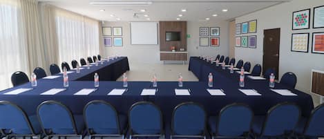 A conference room with a long table, chairs, and water bottles.