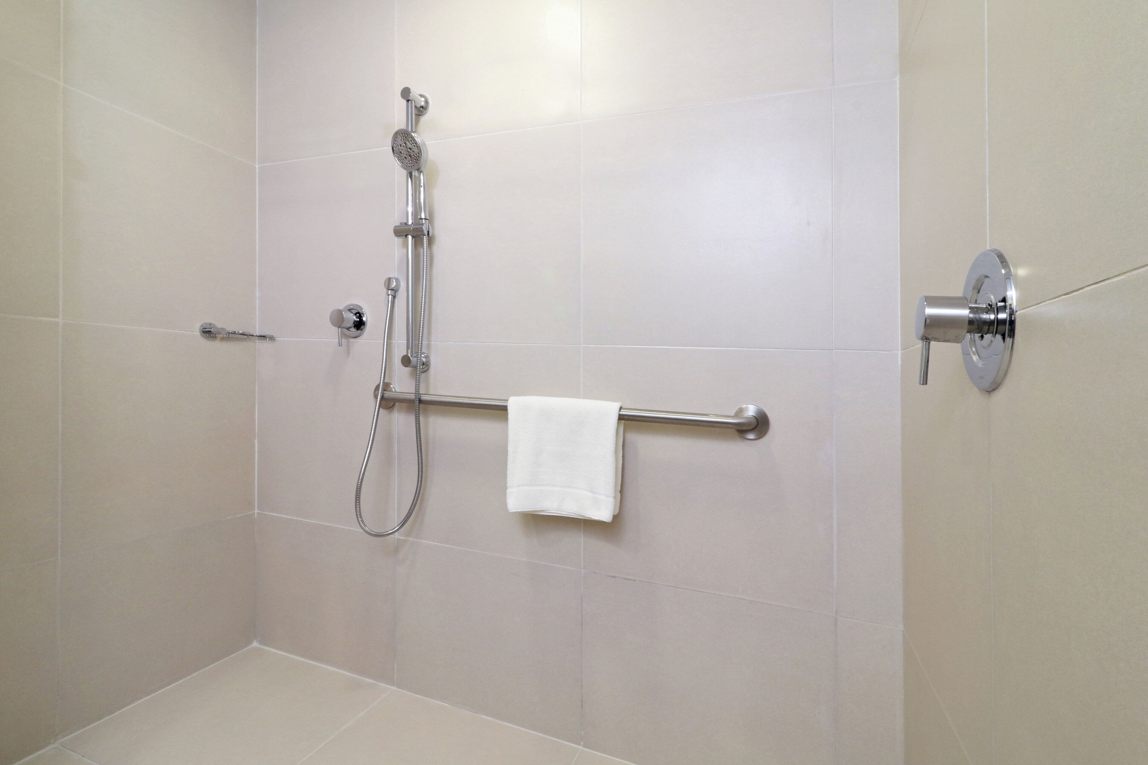 A bathroom with a shower, a towel rack, and a toilet.