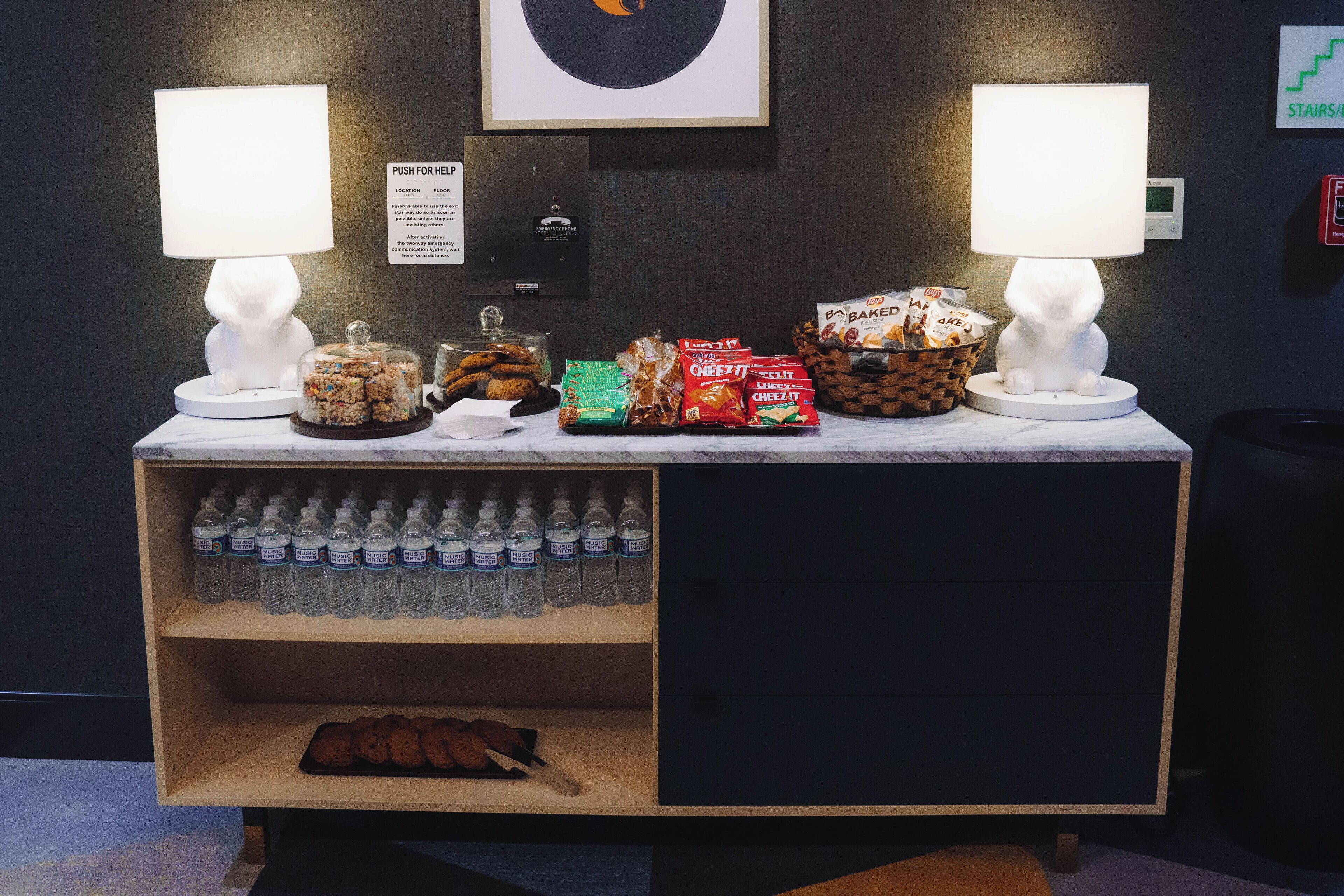 A snack station with various food items and bottled water.