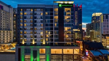 A modern lobby with a bar area, seating arrangements, and a reception desk. at Holiday Inn & Suites Nashville Downtown - Broadway by IHG
