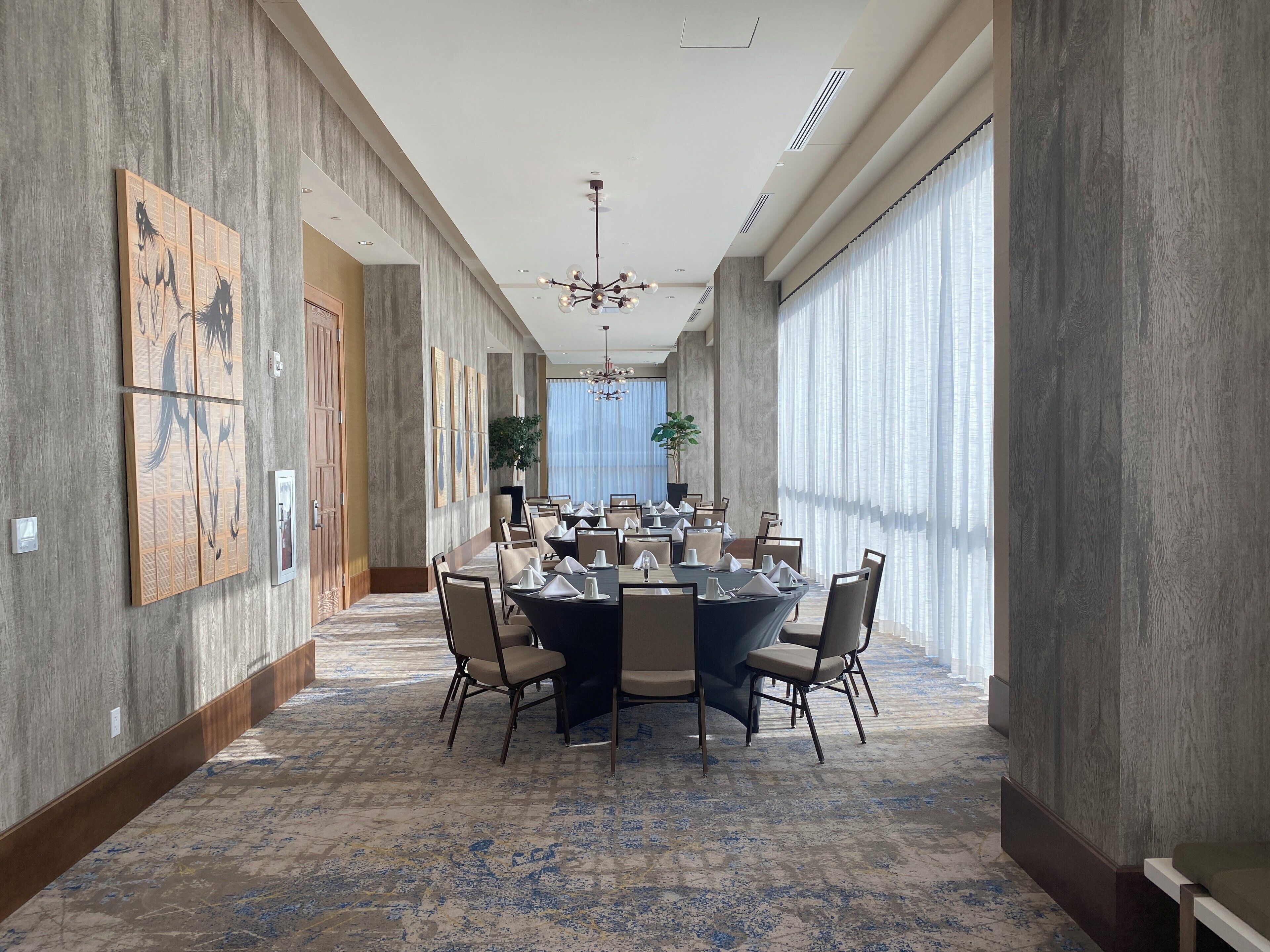 A conference room with a long table, chairs, and a chandelier.